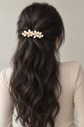 Ivory Blossom Barrette securing a half-up style in long, wavy brown hair.