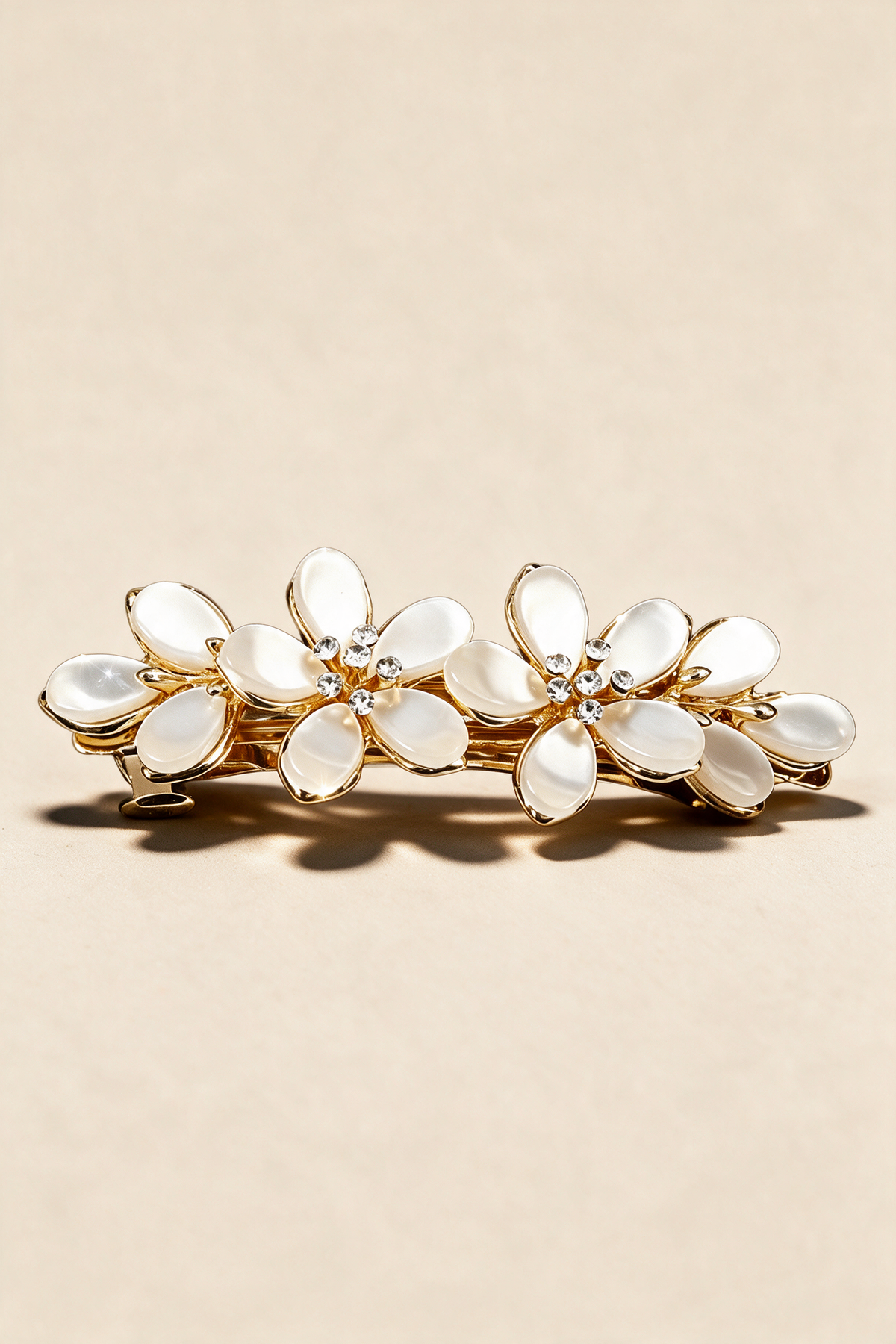Ivory Blossom Barrette with two ivory flowers, sparkling centres and a gold-tone frame.