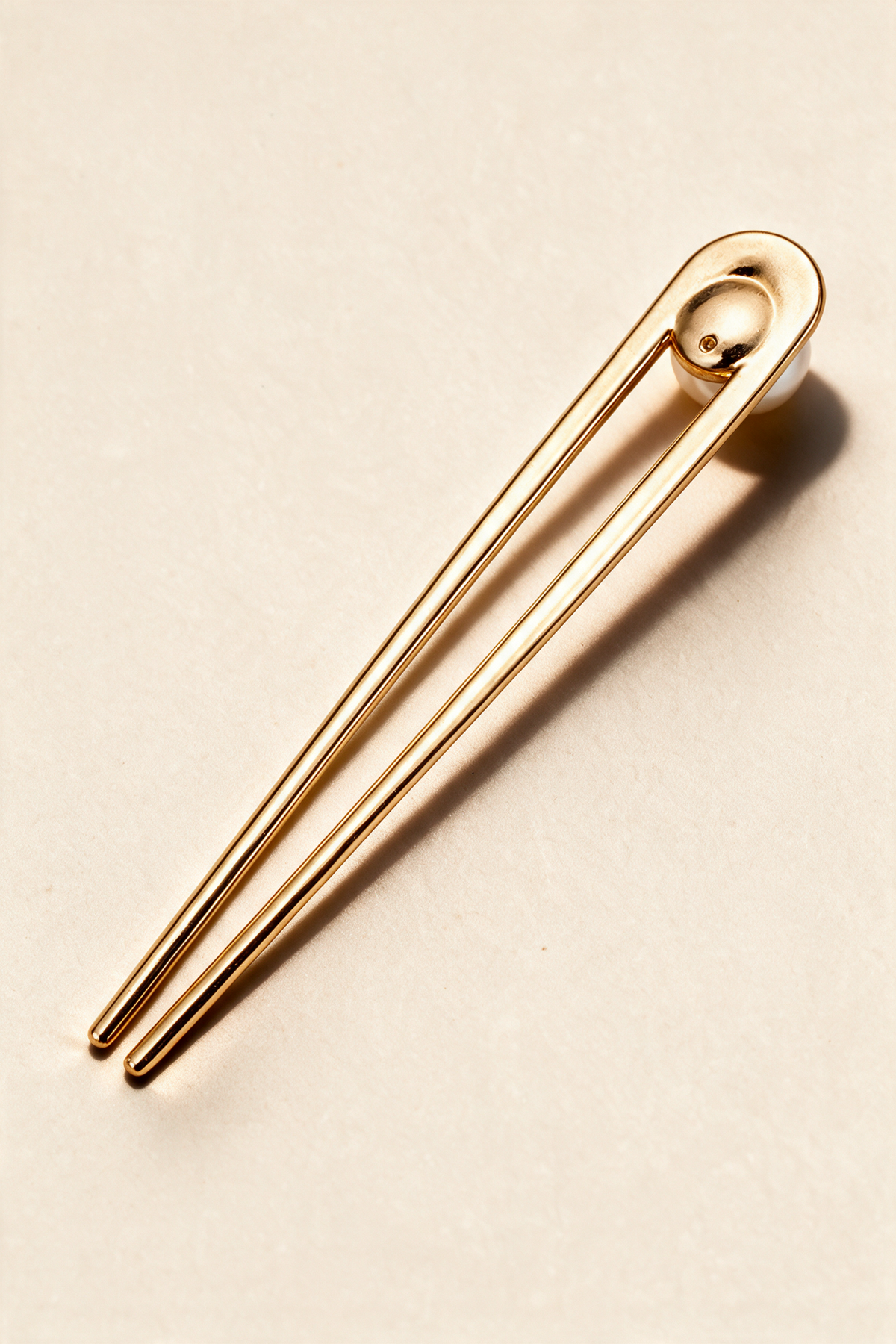 Back of the gold-tone Pearl U-Pin showing its curved head and two prongs.