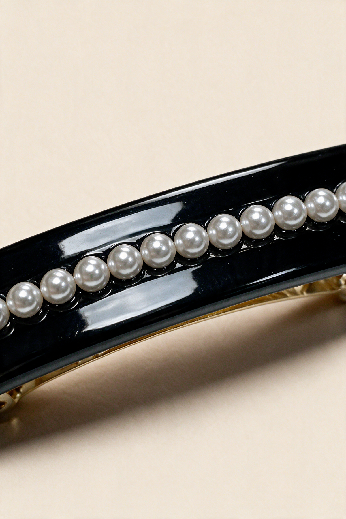 Close-up of the Black Pearl River Barrette's pearl-effect beads and glossy finish.